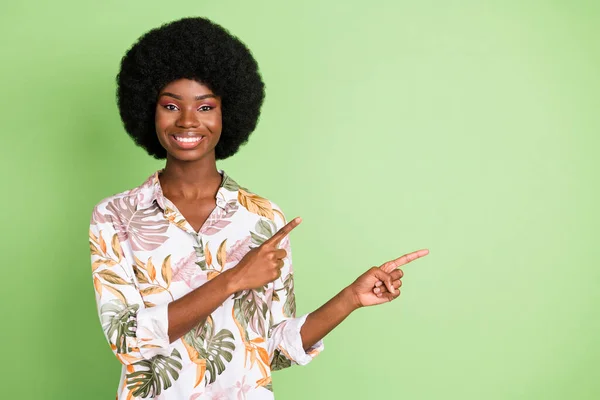 Foto de chica negra atractiva joven feliz sonrisa positiva punta dedos espacio vacío anuncio consejo opción aislado sobre fondo de color verde — Foto de Stock