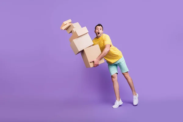 Foto de cuerpo completo de sorprendido sorprendido hombre problemático caída cajas mover cartón aislado sobre fondo de color púrpura — Foto de Stock