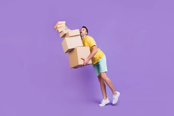 Longitud completa cuerpo tamaño foto hombre caminando con la caída de cajas de cartón aislado pastel violeta color fondo — Foto de Stock