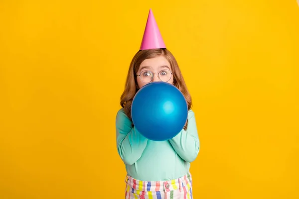 Foto van jonge tiener meisje blazen luchtballonnen verjaardag feest decoratie geïsoleerd over gele kleur achtergrond — Stockfoto