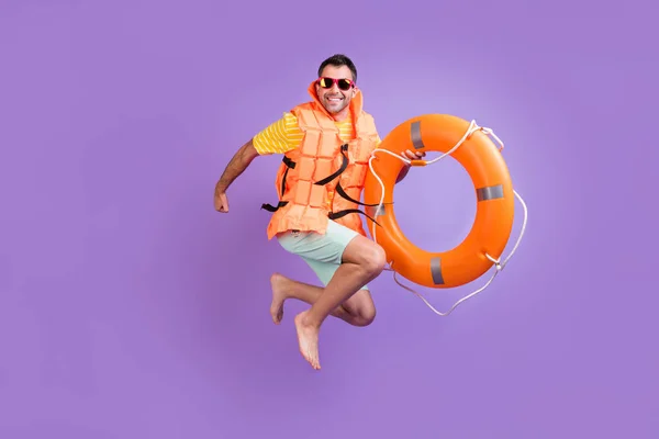 Foto lateral de perfil de tamaño completo del joven feliz sonrisa positiva salto mantenga el círculo de rescate aislado sobre fondo de color violeta —  Fotos de Stock