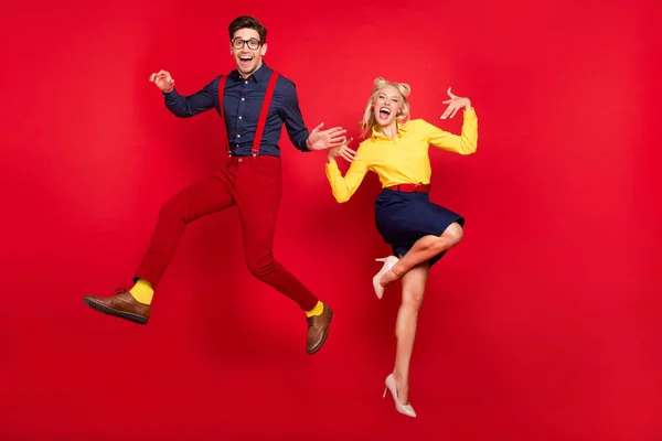 Volledige lichaamsomvang uitzicht van aantrekkelijke vrolijke paar springen gek dansen jive lindy geïsoleerd over helder rood kleur achtergrond — Stockfoto