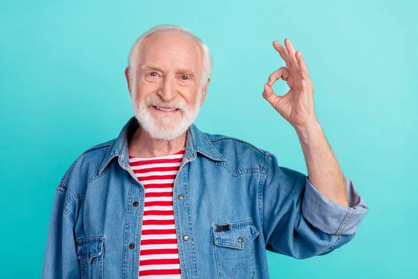 Portrét atraktivní veselý šedovlasý muž ukazuje ok-znamení reklamní řešení dohodnout izolované přes světlé tyrkysové barvy pozadí — Stock fotografie