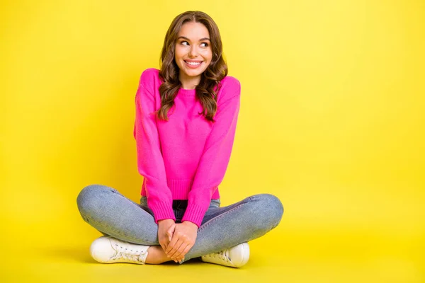 Full size foto di giovane felice sorridente ragazza positiva guardare copyspace sedersi piano con le gambe piegate isolato su sfondo di colore giallo — Foto Stock
