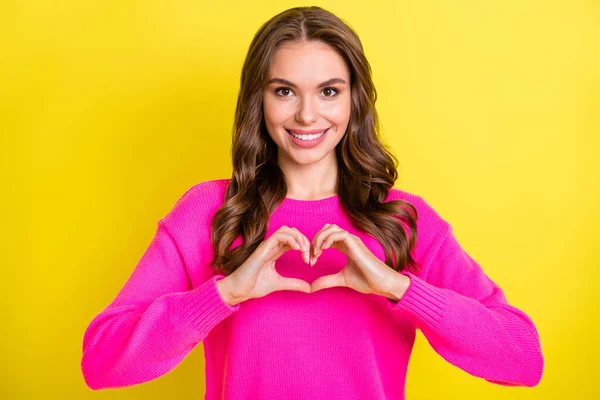 Foto de sedutor encantador ondulado jovem mulher usar camisola rosa mostrando dedos coração isolado cor amarela fundo — Fotografia de Stock