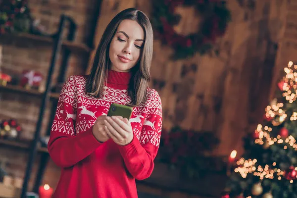 Zdjęcie błyszczącej słodkiej pani nosić czerwony pullover uśmiechając wysyłając nowoczesne urządzenie Boże Narodzenie gratulacje w domu domu dom pokój — Zdjęcie stockowe