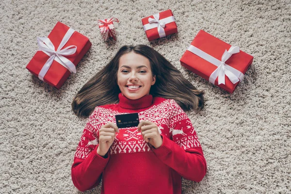 Top view photo of cheerful lady lay floor boxes gift demonstrate debit card wear pullover in decorated x-mas home indoors — Stock Photo, Image