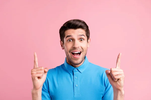 印象的なブルネットの若い男の写真をポイントアップピンクの色の背景に隔離された青のTシャツを着用 — ストック写真