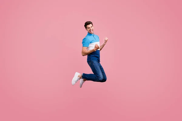 Full body profile photo of cool brunet young guy jump wear polo jeans sneakers isolated on pink background — Stock Photo, Image