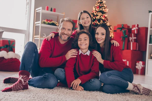 Full size foto van droom familie knuffel zitten samen op tapijt dragen rode truien jeans sokken x-mas binnen — Stockfoto