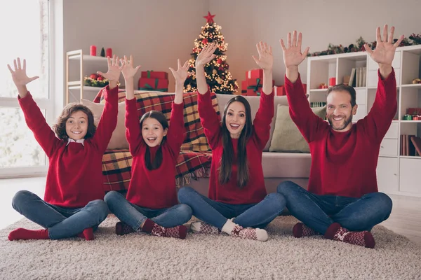 Foto de atraente engraçado pai mãe duas crianças vestidas camisolas vermelhas subindo braços sorrindo dentro de casa quarto casa — Fotografia de Stock