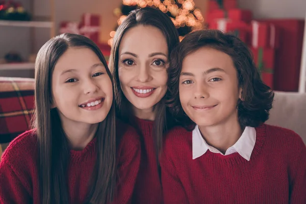 Photo of attractive cute mom son daughter wear red pullovers smiling celebrating christmas hugging indoors house home room — Stock Photo, Image