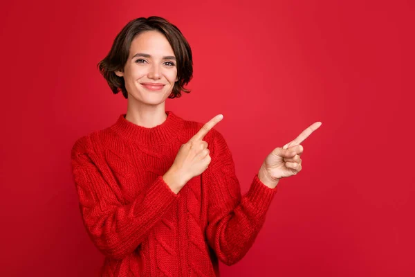 Foto de jovem atraente mulher feliz sorriso positivo indicar dedos espaço vazio promo anunciar isolado sobre fundo de cor vermelha — Fotografia de Stock