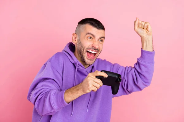 Foto van hooray millennial brunet guy playstation dragen violet hoodie geïsoleerd op roze achtergrond — Stockfoto