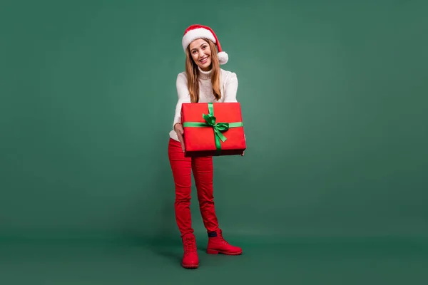 Full längd kroppsstorlek bild av attraktiv glad kvinna håller ger dig presentbox dans isolerad över grön färg bakgrund — Stockfoto
