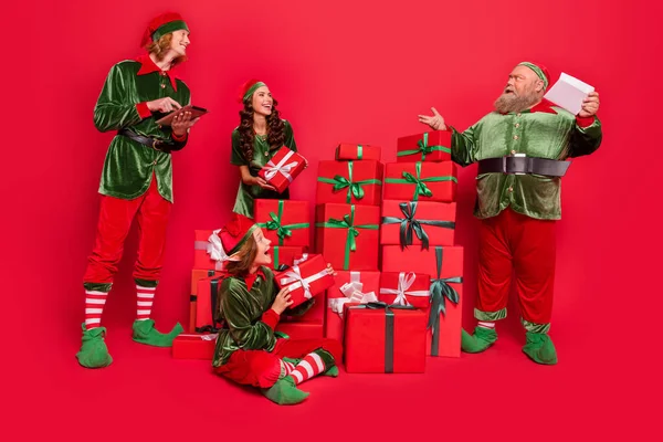Volledige lichaamsomvang uitzicht van aantrekkelijke vrolijke vrienden elf verzenden feestelijke geschenkdozen geïsoleerd over helder rode kleur achtergrond — Stockfoto