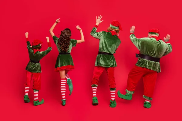 Задний вид позвоночника полный размер фото людей эльф пользуются поднять руки танца Рождество Рождество изолированы на красном фоне цвета — стоковое фото