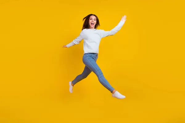 Volledige lengte foto van gelukkig jonge vrouw springen lopen genieten goed humeur geïsoleerd op geel kleur achtergrond — Stockfoto