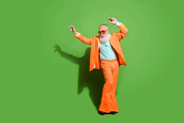Vista completa del tamaño del cuerpo del atractivo hombre de pelo gris elegante bailando usando especificaciones aisladas sobre fondo de color verde brillante —  Fotos de Stock
