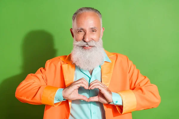 Portrait d'un homme aux cheveux gris joyeux montrant le symbole du cœur isolé sur fond vert vif — Photo