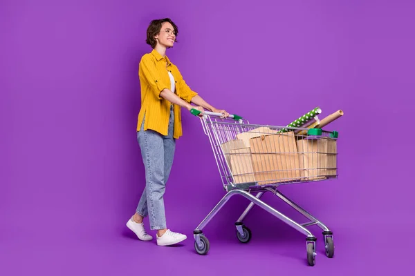 Longitud completa vista del tamaño del cuerpo de la chica alegre agradable va llevando mercancías tienda de arte aislado sobre violeta brillante color púrpura fondo — Foto de Stock