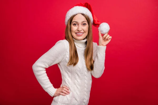 Portrét atraktivní dívčí veselá žena na sobě novoroční vzhled drží klobouk míč izolované přes jasně červené barvy pozadí — Stock fotografie