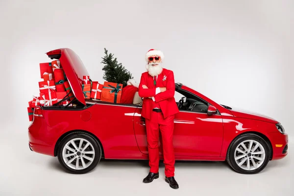 Photo de santa claus assez confiant équitation bras de voiture pliés offrant des cadeaux isolés fond de couleur blanche — Photo