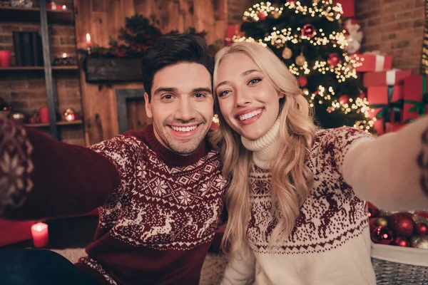 楽観的なカップルの写真ありませんセルフィーは醜いセーターを身に着けています屋内近くの木の上にX-mas eve — ストック写真