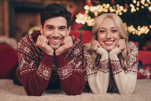Zdjęcie cute uroczy żona mąż ubrany druk pulowerów świętując nowy rok uśmiechając się w pomieszczeniu domu — Zdjęcie stockowe
