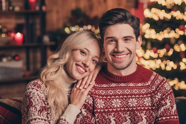 Foto de la adorable esposa joven marido usan suéteres de impresión sonriendo abrazando disfrutando de Noel tiempo en el interior casa casa habitación —  Fotos de Stock