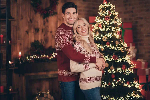 Foto de adorable esposa bonita marido vestido impresión pullovers celebrando el milagro de Navidad sonriendo en el interior habitación casa —  Fotos de Stock