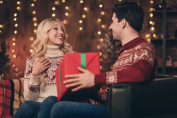 Zdjęcie uroczej żony zachwycony mąż ubrany pulowery druku coraz Boże Narodzenie pozdrowienia uśmiechając się w pomieszczeniu domu domu — Zdjęcie stockowe