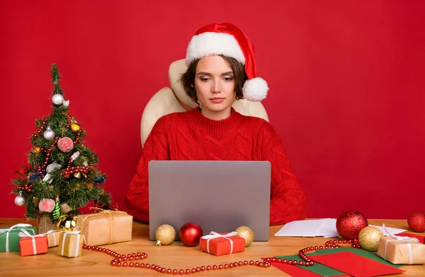 Zdjęcie portret młoda kobieta siedzi przy stole za pomocą laptopa odizolowane jasnoczerwony kolor tła — Zdjęcie stockowe
