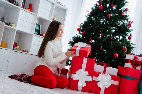 Foto van schattige opgewonden jonge vrouw gekleed witte trui opening geschenken glimlachen binnen huis kamer — Stockfoto