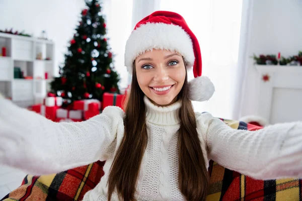 Foto de atraente bela jovem mulher vestida camisola branca headwear gravação de vídeo sorrindo dentro de casa casa quarto — Fotografia de Stock