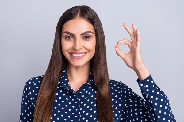 Фото веселой молодой женщины показывают пальцы хорошо знак рекомендуем рекламировать улыбку изолированы на сером фоне цвета — стоковое фото