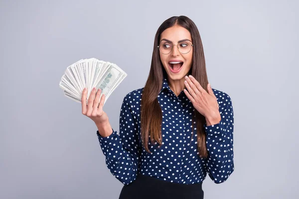 Ritratto di attraente stupito allegra donna d'affari in possesso di denaro usd economia ventilatore isolato su sfondo di colore grigio — Foto Stock