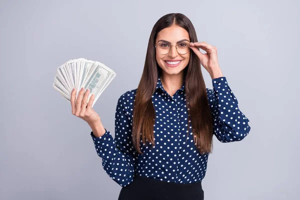 Ritratto di attraente donna d'affari allegra in possesso di denaro del ventilatore usd toccando specifiche isolate su sfondo di colore grigio — Foto Stock