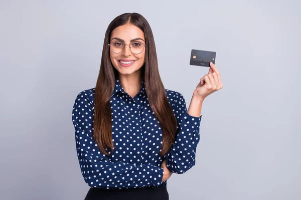 Fénykép magabiztos bankár hölgy hold betéti kártya visel szemüveg pontozott blúz elszigetelt szürke színű háttér — Stock Fotó
