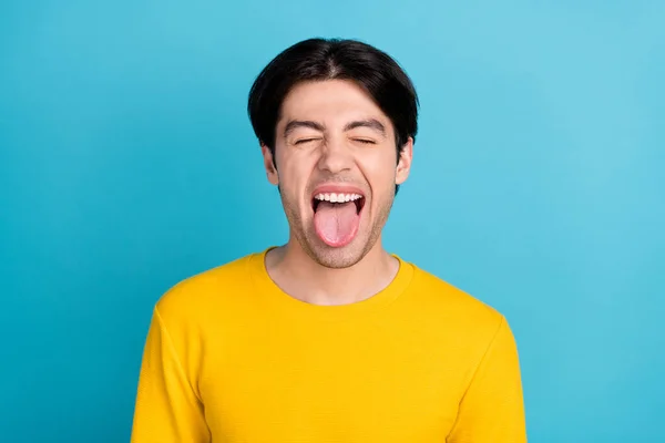 Foto de un joven feliz sonrisa positiva engañando mueca lengua-hacia fuera aislado sobre fondo de color azul — Foto de Stock