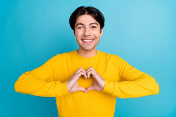 Foto von jungen Mann glücklich positives Lächeln zeigen Finger Herz Symbol Liebe Amor romantisch isoliert über blauer Farbe Hintergrund — Stockfoto