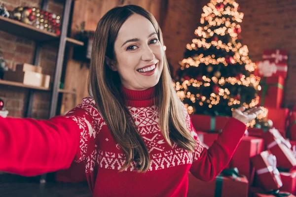 Фото красивої солодкої зрілої леді в червоному пуловері, посміхаючись записуючи різдвяні відео привітання в приміщенні будинку домашньої кімнати — стокове фото