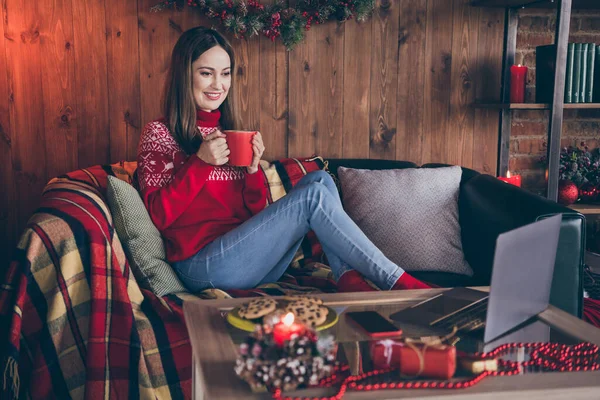Foto av charmig söt ung kvinna klädd röd tröja titta på modern pryl nyårsfilm dricka te inomhus rum hem hus — Stockfoto
