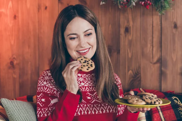 Photo de jolie adorable jeune femme habillée pull rouge mangeant biscuits maison nouvelle année souriant maison de maison de chambre intérieure — Photo
