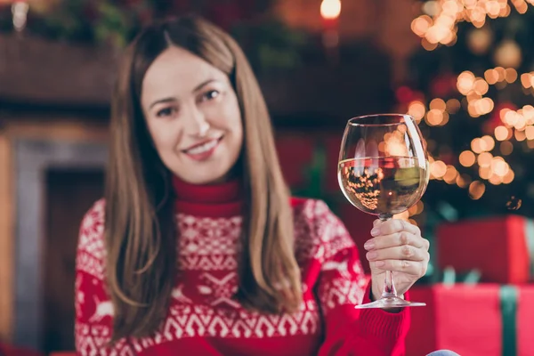 Фото очаровательной зрелой дамы, одетой в красный пуловер, улыбающейся, наслаждаясь Рождеством, пьющей шампанское в помещении домашней комнаты — стоковое фото