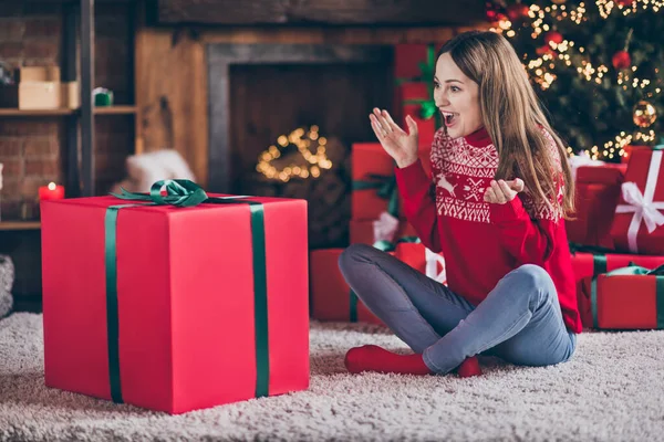 Foto de linda señora madura impresionada usar jersey rojo sonriendo conseguir Navidad caja de regalo grande interior casa casa habitación —  Fotos de Stock