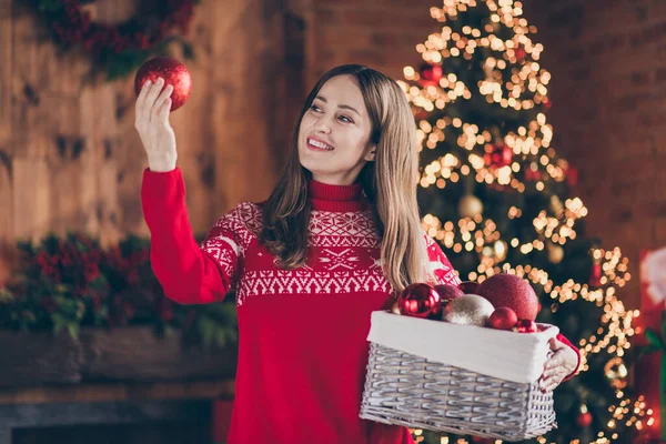 Foto de encantadora senhora madura alegre usar pulôver vermelho sorrindo segurando bola de Natal dentro de casa casa casa quarto — Fotografia de Stock