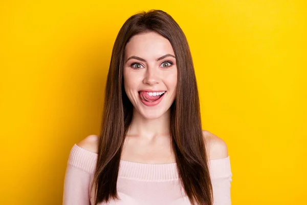 Fénykép az optimista barna hölgy nyelv out kopás rózsaszín ing elszigetelt élénk sárga színű háttér — Stock Fotó