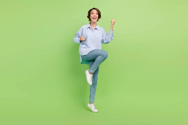Foto de larga duración de la joven mujer emocionada feliz sonrisa positiva regocijarse éxito victoria aislado sobre fondo de color verde —  Fotos de Stock