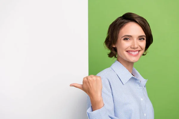 Photo de brune jeune femme heureuse pouce doigt vide planche d'espace isolé sur fond de couleur verte — Photo